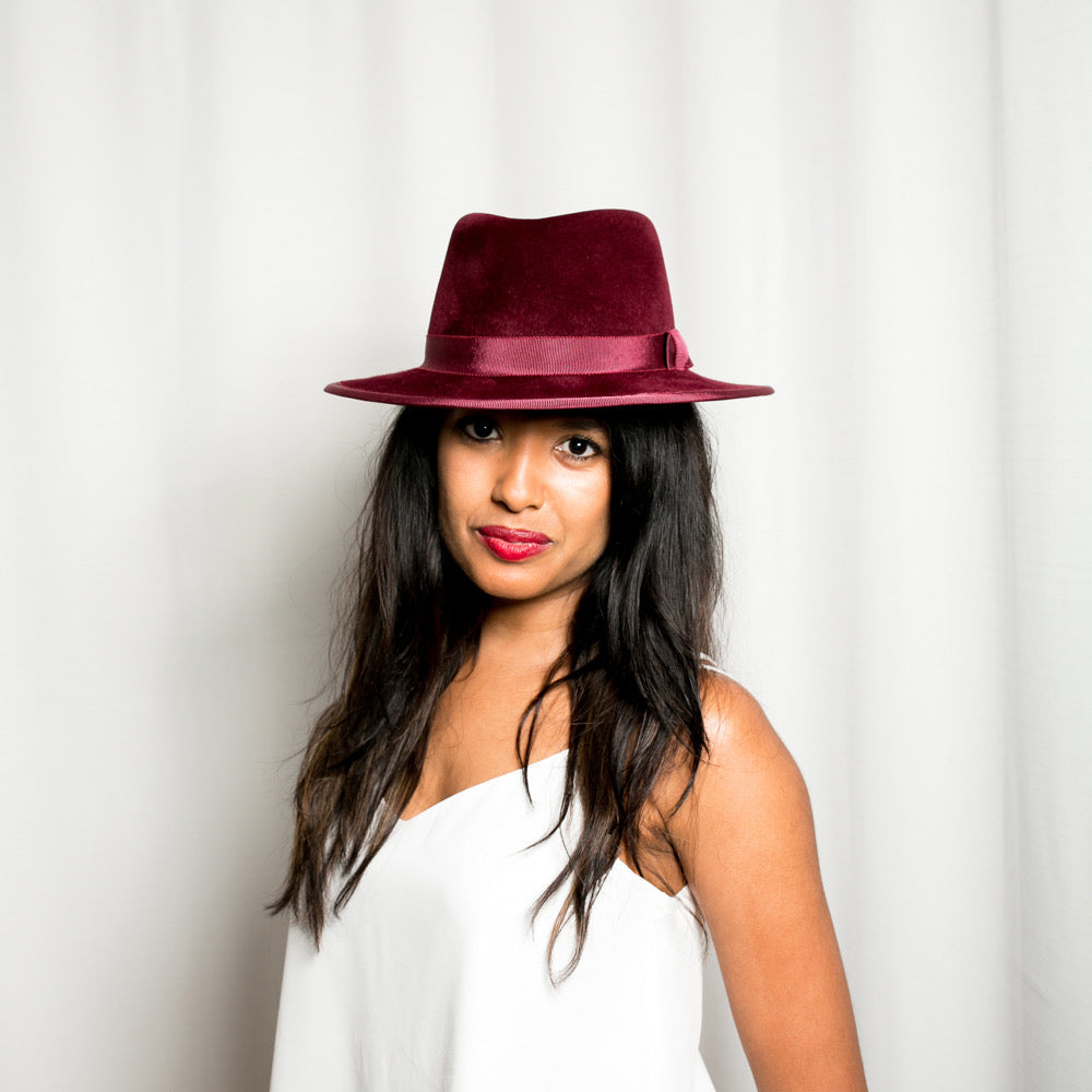 Woman wearing a burgundy hat against a white background