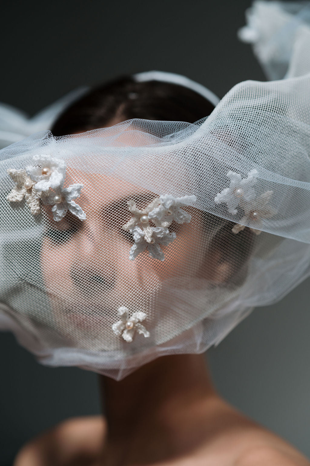 Close-up of a veil with floral embellishments on a dark background