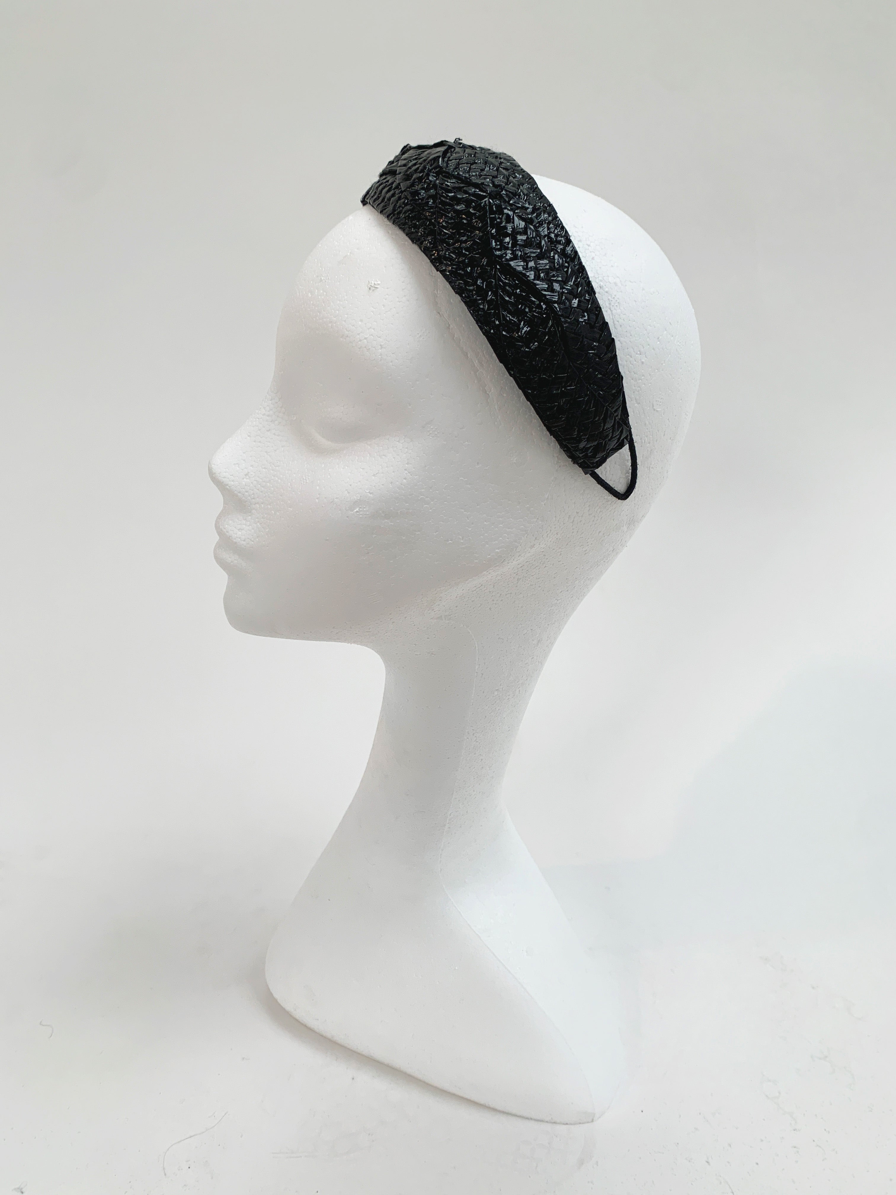 Black textured headband on a mannequin head against a white background