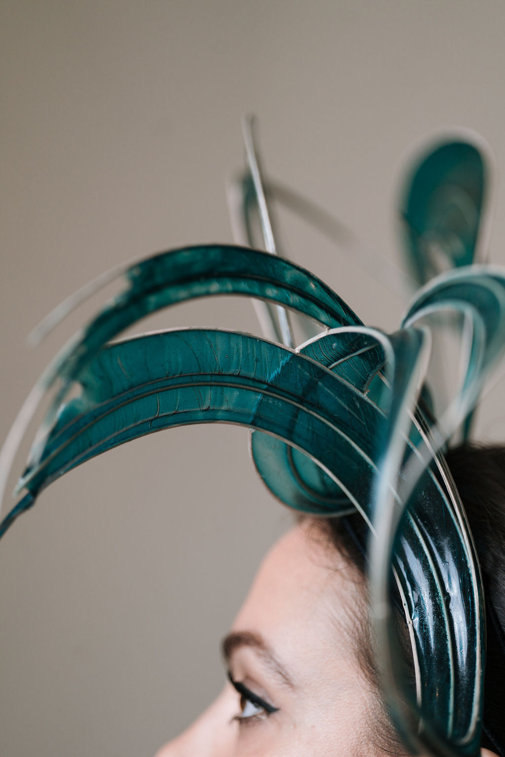 Close-up of a teal and clear bio-plastic headpiece worn by a person.
